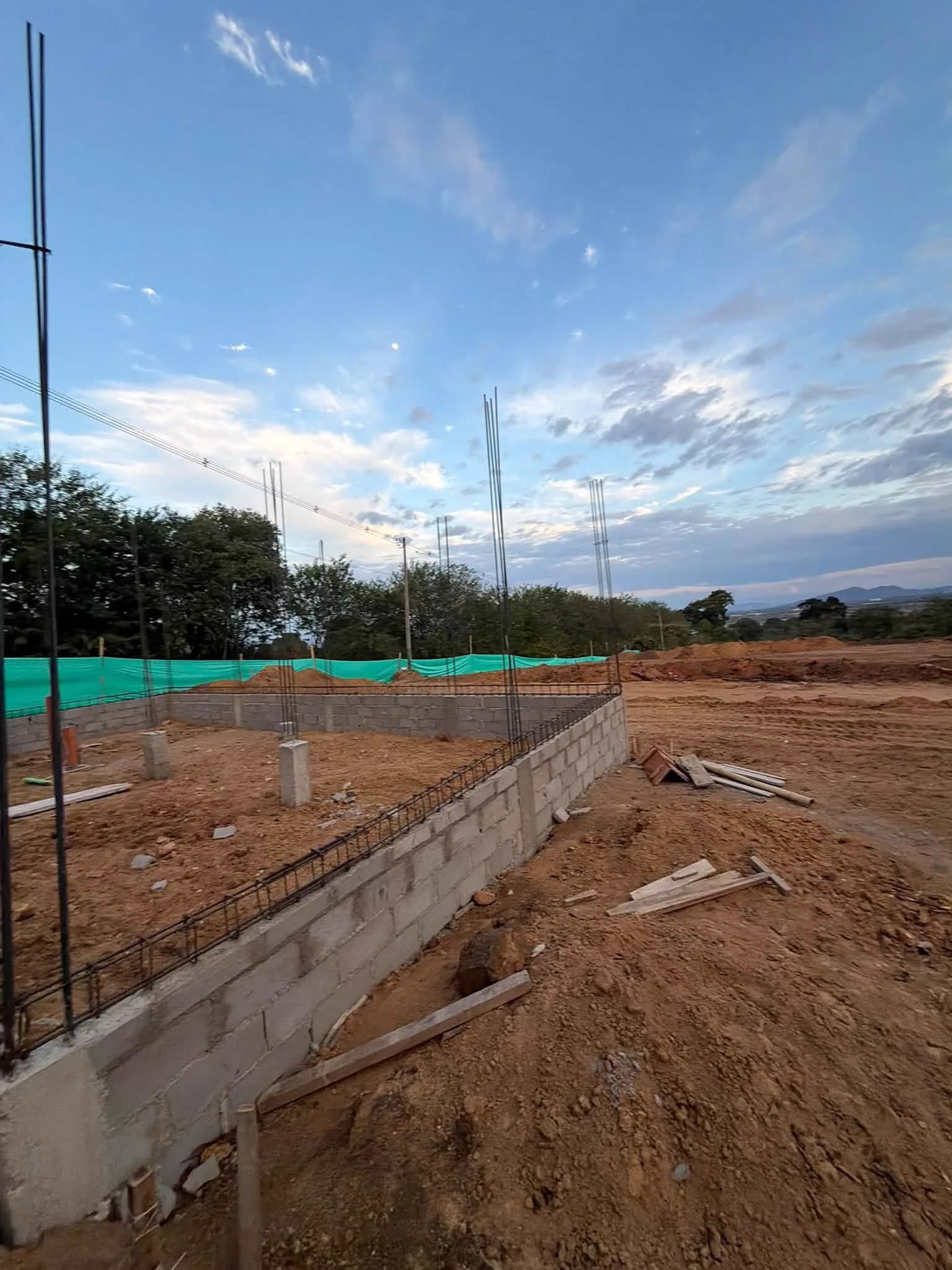 Muro perimetral en bloque con refuerzo, siguiendo el borde del lote.